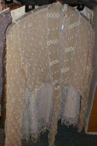Lace net shrug decorated with cream pearls and beads.