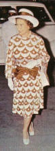 The queen in a dress with coffe and cream scallop pattern and accessories