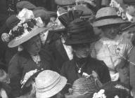 The black hat is a typical hat style of 1910 which is used to date the picture.