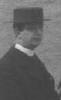 Man wearing clerical collar, possibly the church minister.