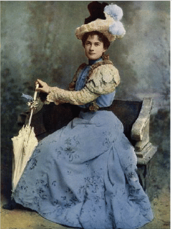 Picture of Grace Palotta wearing a blue dress with cream passementerie sleeves. Edwardian fashion history and costume history.