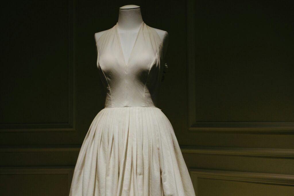 A minimalist wedding dress on a mannequin featuring a deep V-neck bodice and a full pleated skirt