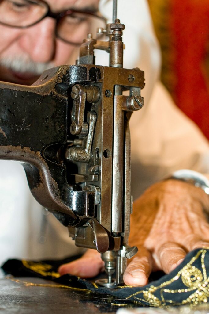 Traditional Tailor Working with a Vintage Industrial Sewing Machine