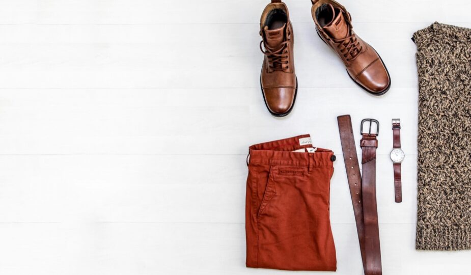 Brown leather shoes with rust-colored trousers in a flat lay.