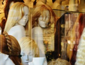 Assorted wigs in blonde, brunette, black, and red displayed on mannequin heads