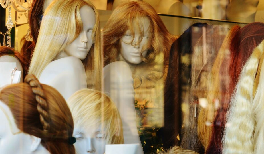 Assorted wigs in blonde, brunette, black, and red displayed on mannequin heads